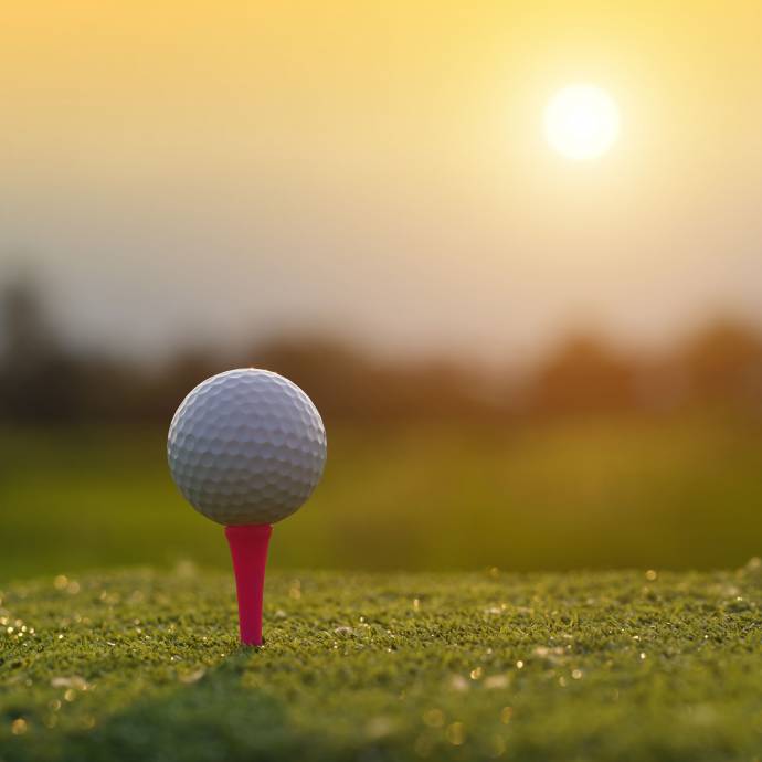 Golfball auf Golfplatz im Sonnenuntergang